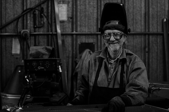 Photo of an older man in welding clothes