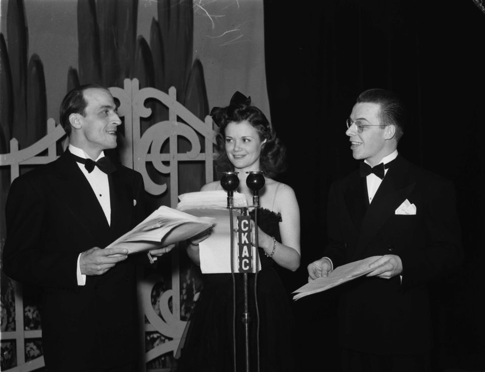 Photo of three people in front of a microphone