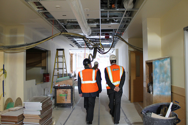 Construction workers touring a building with their hard hats on
